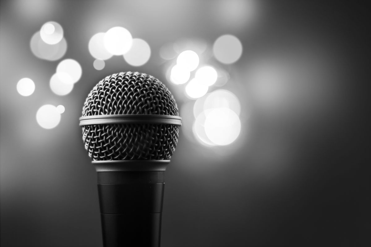 Close up of a professional microphone with blurred lights in the background - party, concert, karaoke concept